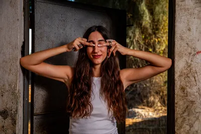 בחורה_עומד_בפתח_של_חדר_במבנה_נטוש_בוגרת_את_העיניים_עם_הידיים_בוק_אישי