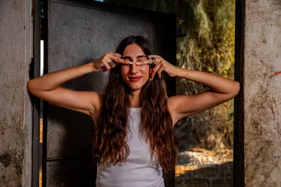 בחורה_עומד_בפתח_של_חדר_במבנה_נטוש_בוגרת_את_העיניים_עם_הידיים_בוק_אישי
