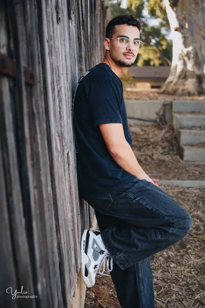 בחור_עומד ליד_קיר_עץ_צילומים_אישיים