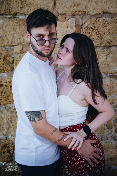 גבר_ואישה_מתחבקים_על_רקע_קיר_לבנים_צילומי_זוגיות