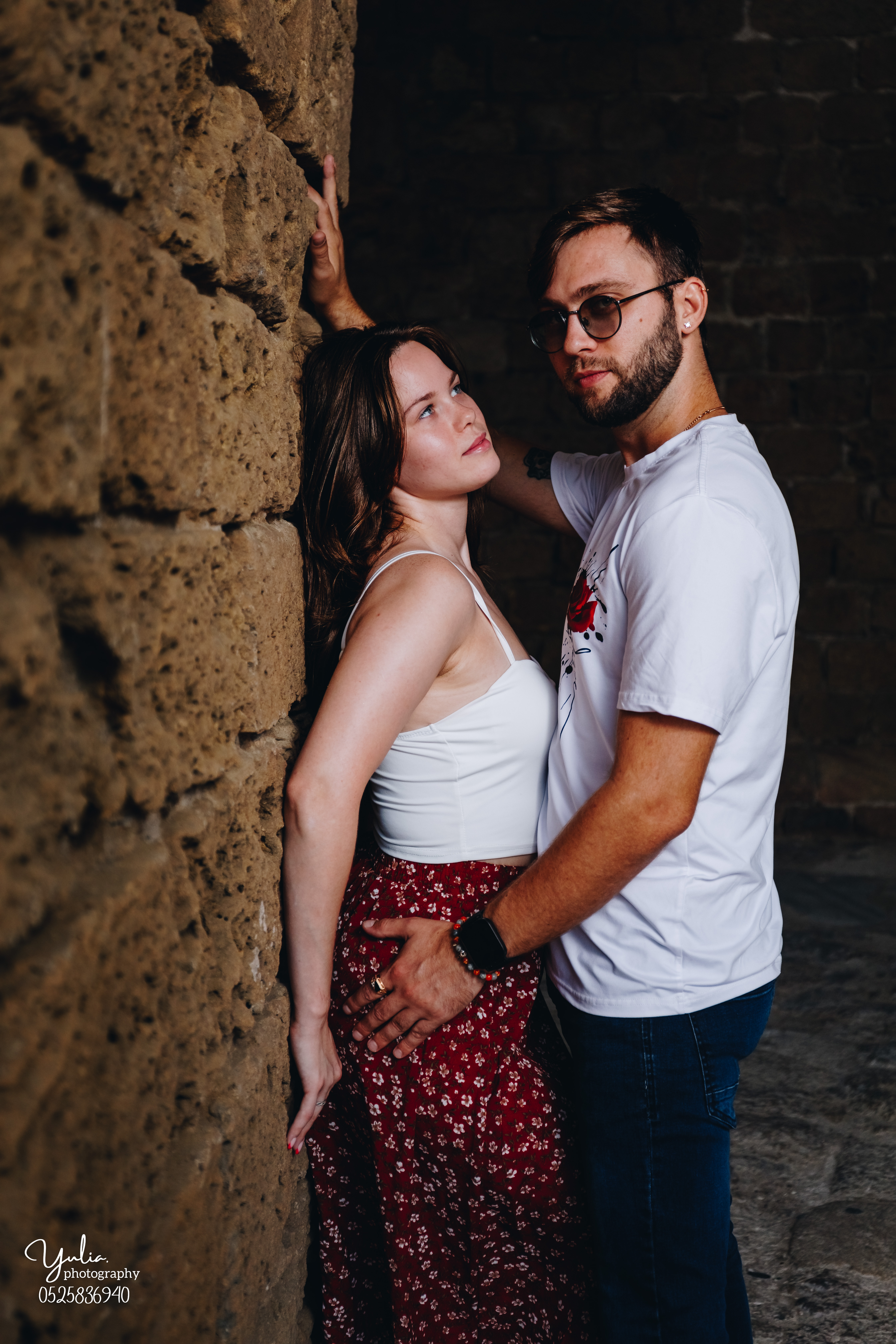 צילומי זוגיות אינטימיים וחושניים זוג עומד ליד קיר לבנים בקיסריה