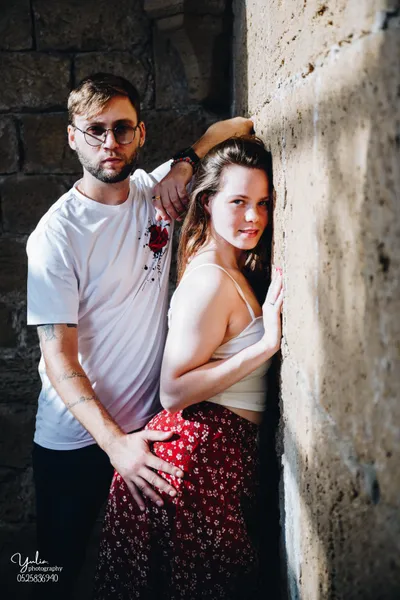 גבר_בחולצה_לבנה_ובחורה_עם_חצאית_אדומה_צלמת_מומלצת_במרכז