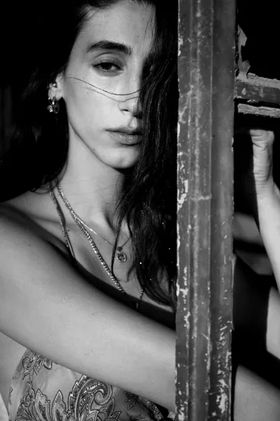 בחורה_עם_מששקפי_שמש_עומדת_מאחורי_חלון_עם_סורגים_צילומי_תדמית_